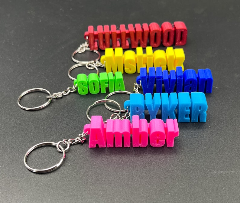 May include: A set of six colorful keychains with the names "Hollywood", "Mshek", "Vivian", "Ryker", and "Amber" printed on them.