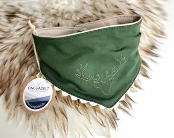 May include: A dark green triangular bandana with a beige interior lining and a white scalloped edge trim. The front features a stitched outline of a deer head. A round cardboard tag is attached, displaying the text EING'FADELT and a website URL.