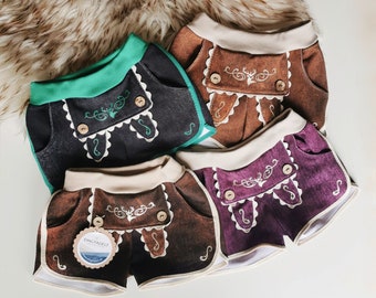 May include: Three pairs of toddler shorts in brown, black, and purple with white trim and embroidery. The shorts have a deer design and the text "KINGFADEIT" on a tag.