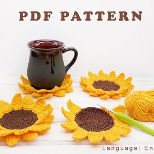 May include: Four crocheted sunflower coasters in yellow and brown with a brown ceramic mug on top of one of the coasters. The text "PDF PATTERN" is at the top of the image. The image also includes a ball of yellow yarn and a crochet hook.