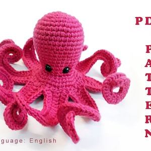 Könnte beinhalten: Ein handgefertigter, leuchtend rosa gehäkelter Oktopus mit schwarzen Sicherheitsaugen. Der Oktopus hat acht lockige Tentakel und einen abgerundeten Kopf. Das Bild enthält den Text "PDF PATTERN" in Pink und "Language: English".