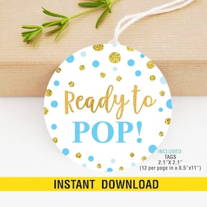 以下が含まれることがあります： 「Ready to POP!」の文字が金色と水色で書かれた丸い白いタグ。金色のグリッターと水色の水玉模様で装飾されています。タグのサイズは5.3cm x 5.3cmで、インスタントダウンロードです。