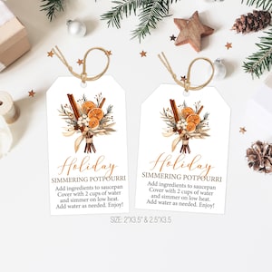 Puede incluir: Dos etiquetas de regalo blancas con una cuerda de yute marrón. Las etiquetas presentan una ilustración de acuarela de un ramo de palitos de canela, naranjas secas y vegetación. El texto en las etiquetas dice "Holiday Simmering Potpourri" e incluye instrucciones para hacer el popurrí. Las etiquetas están disponibles en dos tamaños: 5 cm por 9 cm y 6,5 cm por 9 cm.