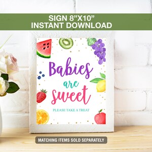 May include: A white framed sign with the text "Babies are sweet" and fruit illustrations. The sign is 8" x 10" and includes a watermelon slice, kiwi, grapes, blueberries, strawberry, lemon, orange slice, and an apple.