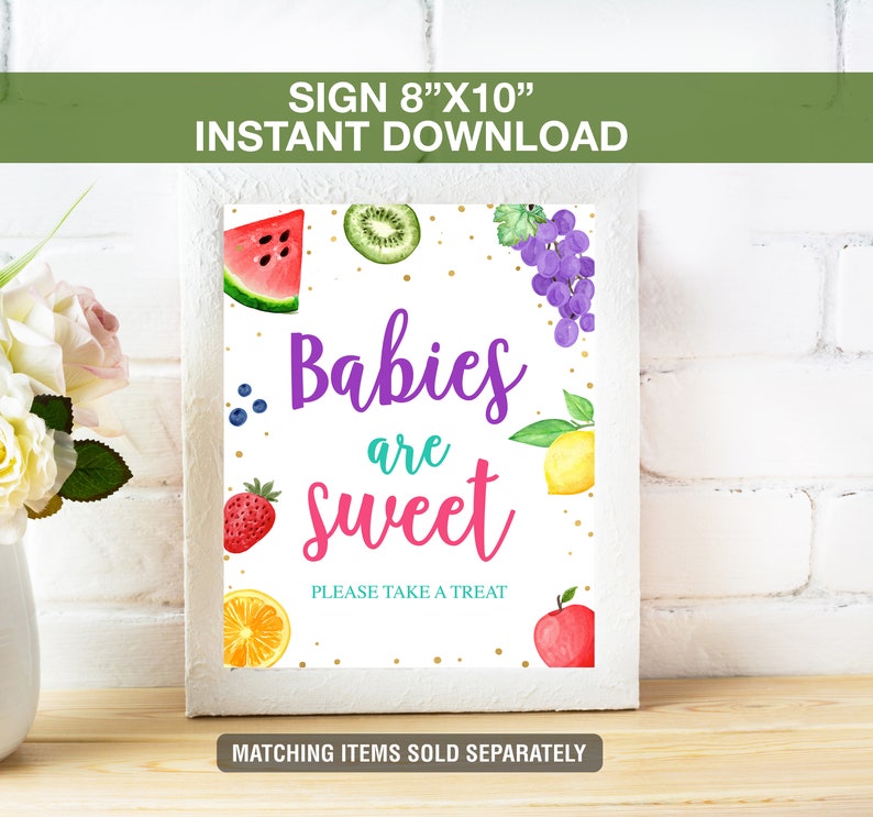 May include: A white framed sign with the text "Babies are sweet" and fruit illustrations. The sign is 8" x 10" and includes a watermelon slice, kiwi, grapes, blueberries, strawberry, lemon, orange slice, and an apple.