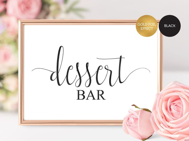 May include: A printable sign with a gold foil effect that says "dessert bar" in a cursive font. The sign is in a rose gold frame and is sitting on a white surface.
