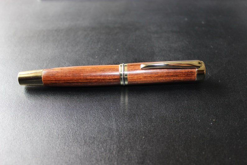 Includes a gift box. Handcrafted Iridium Gold Fountain Pen with Wooden Body