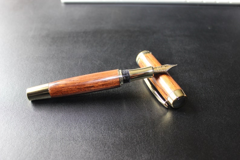 Includes a gift box. Handcrafted Iridium Gold Fountain Pen with Wooden Body