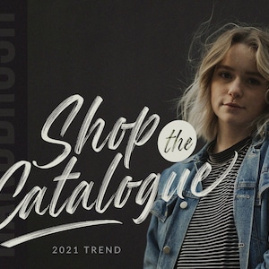 May include: A promotional image with the text "Shop the Catalogue" in a white, handwritten font, with the words "Handbrush" and "2021 Trend" also visible. A person wearing a denim jacket and striped shirt is in the background.