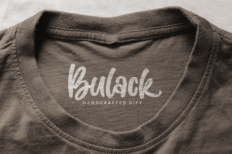 May include: A brown t-shirt with a white, handwritten logo that says "Bullock Handcrafted Gift".