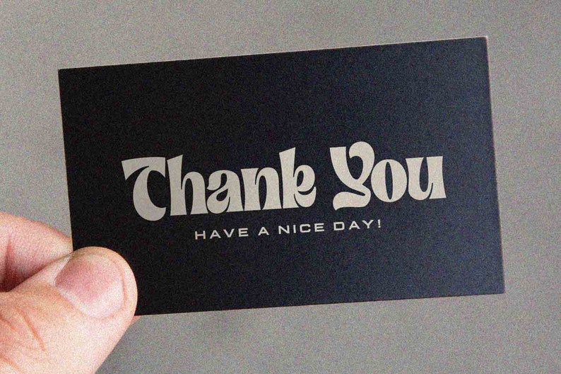 May include: A black card with white text that says "Thank You" in a stylized font. Below the text, it says "Have a nice day!"