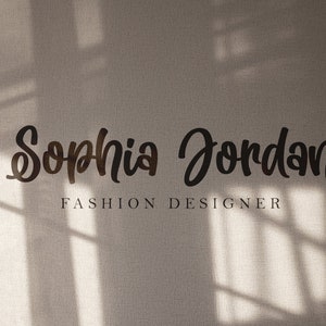 May include: A white wall with a shadow of a window behind the text "Sophia Jordan Fashion Designer".