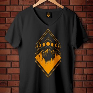 May include: Black V-neck t-shirt with a geometric design in orange. The design features mountains, trees, and phases of the moon. The text "Vector hand drawn Samples of use" is in a circle in the upper right corner.