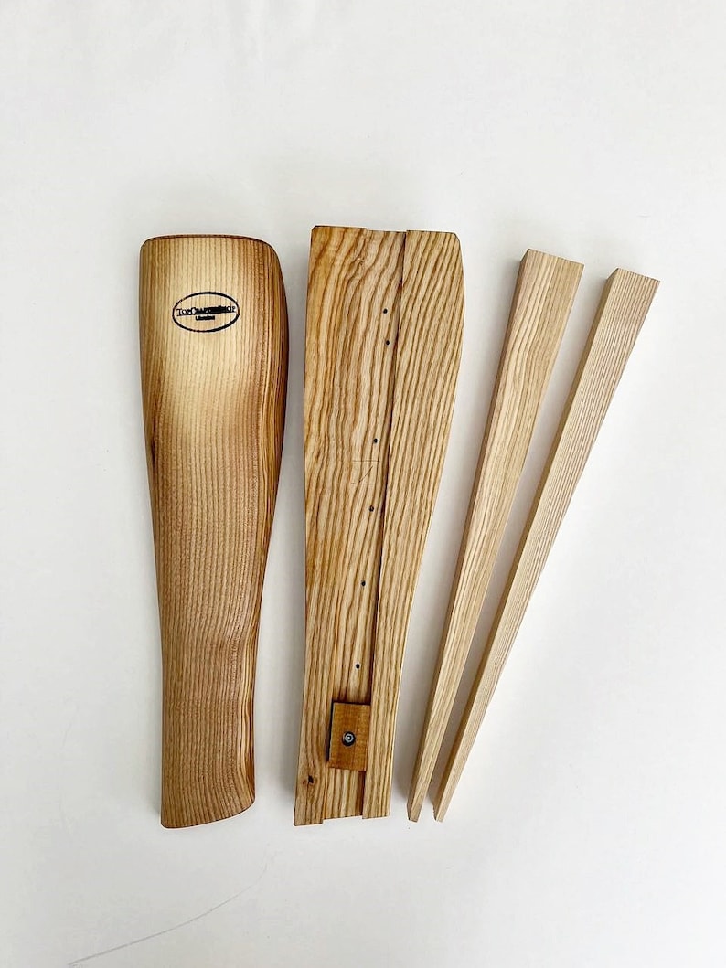 May include: Wooden shoe stretcher with three pieces: a boot-shaped piece, a long rectangular piece, and two thin, long pieces. The boot-shaped piece has the text "The Shoe Stretcher" on it.