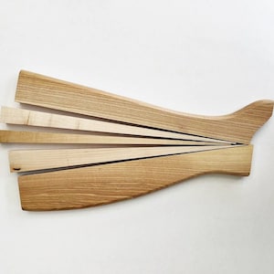 May include: A wooden salad serving set with a long, curved handle and five thin, wooden blades that fan out from the handle.