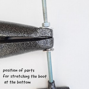May include: A black shoe stretcher with a silver threaded rod and a T-shaped handle. The text "position of parts for stretching the boot at the bottom" is visible in the image.