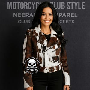 May include: A brown and white cowhide motorcycle jacket with a black lining, silver zippers, and a buckled belt. The jacket has a classic biker style with a notched collar and a small pocket. The text "MOTORCYCLE CLUB STYLE" is visible.