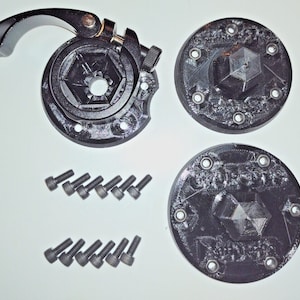 May include: A black metal bike seat post clamp with a lever, two black plastic seat post collars, and 12 black screws.