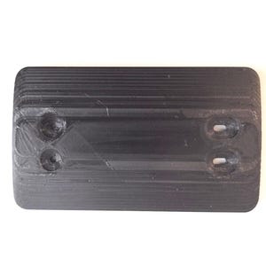 May include: A rectangular, black, 3D-printed object with rounded corners. It features two circular indentations on one end and two oblong holes on the other. The surface has a ridged texture.