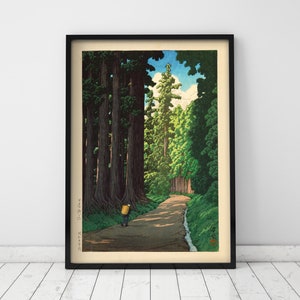 May include: A woodblock print showing a path through a forest of tall trees. The path is lined with trees on both sides, and a single figure walks along the path. The sky is blue with white clouds. The print is framed in black.