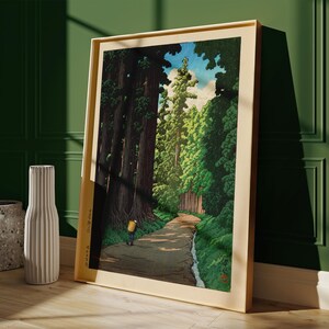 May include: A woodblock print showing a path through a forest of tall trees. The path is lined with trees on both sides, and there is a small stream running along the side of the path. A single figure is walking along the path.