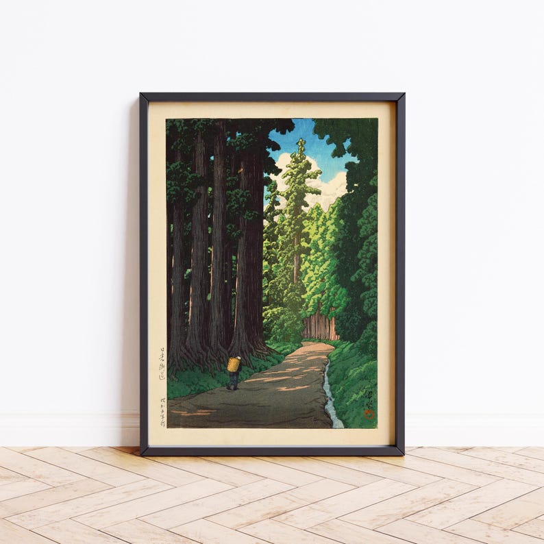 May include: A woodblock print showing a path winding through a forest of tall, dark green trees. A single figure walks along the path, wearing a yellow shirt and carrying a backpack. The sky is blue with white clouds.