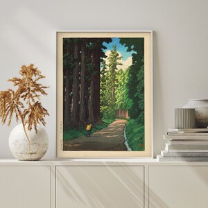 May include: A vintage woodblock print depicting a path through a forest of tall trees. The path leads to a clearing with a single figure walking away from the viewer. The print is framed in a white frame.