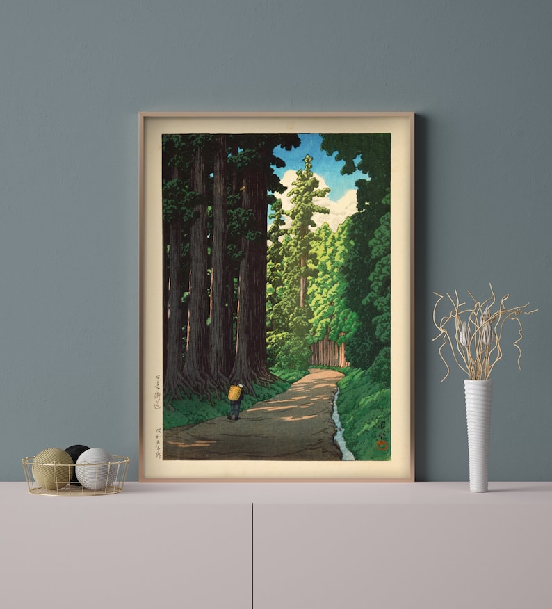 May include: A woodblock print depicting a path through a forest of tall trees. The path is lined with trees on both sides, and a single figure walks down the path. The sky is blue with white clouds.