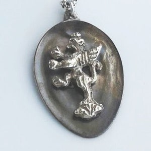 May include: A silver chain necklace with a pendant featuring a detailed silver lion sculpture on a spoon-shaped base.