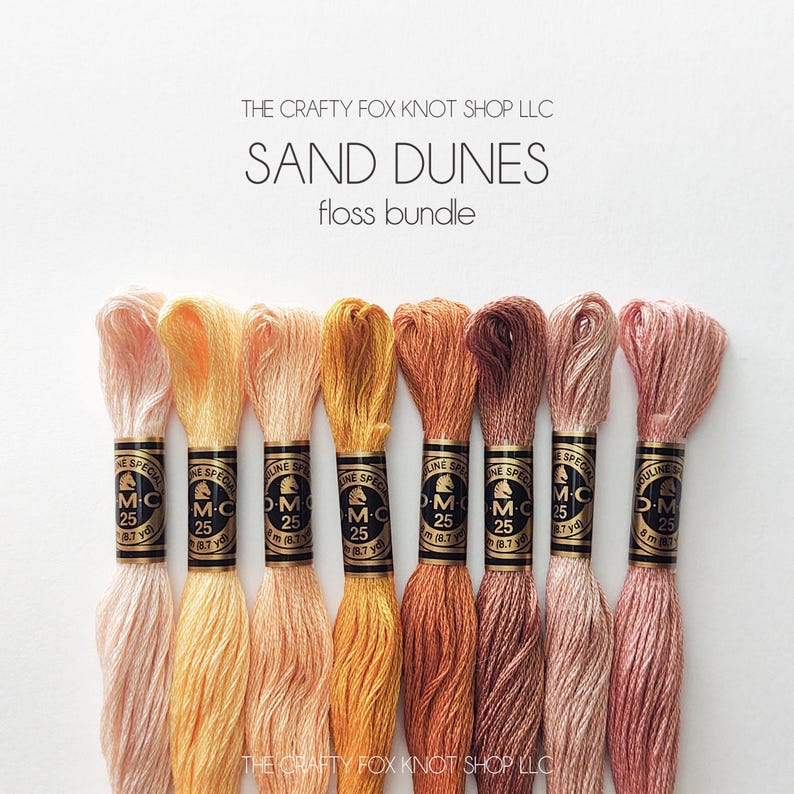 May include: A set of eight DMC embroidery floss spools in shades of peach, orange, and brown. The spools are labeled "DMC Special" and "25". The text "SAND DUNES floss bundle" is at the top of the image.