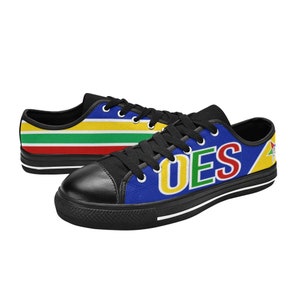 May include: Pair of canvas sneakers with black laces and soles. One shoe features the letters "OES" in yellow, green, and red on a blue background. The other shoe has horizontal stripes of red, green, yellow, and blue.