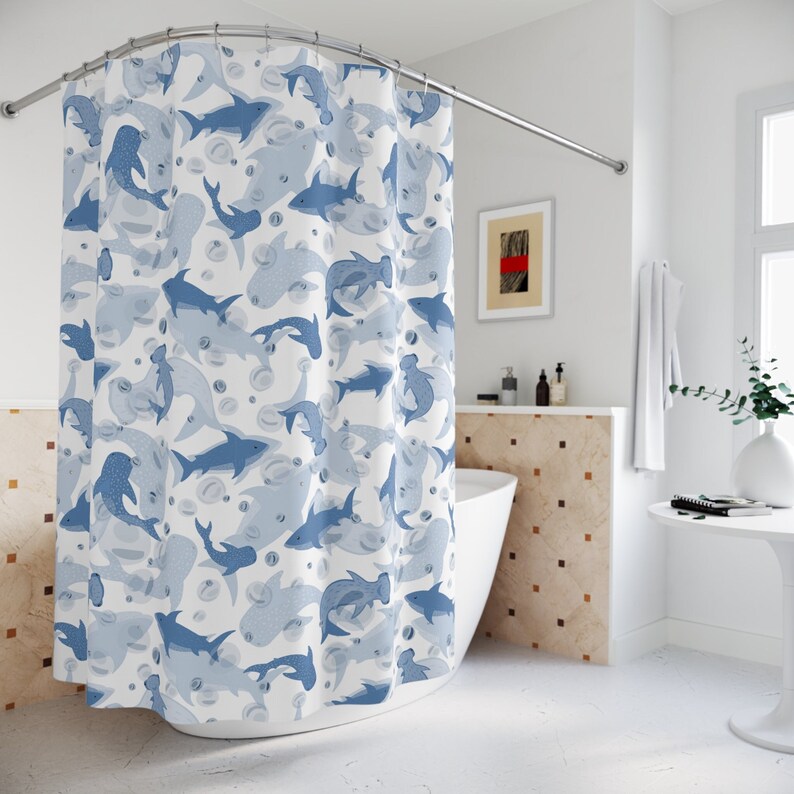 Pu&ograve; includere: Tenda da doccia bianca con un motivo di squali e bolle blu e azzurre. Gli squali, di varie dimensioni e stili, creano un tema acquatico e giocoso. La tenda &egrave; appesa a un'asta curva.