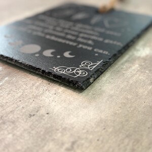 May include: Black slate sign with a white inscription that reads "You are braver than you think, stronger than you seem, and smarter than you believe.  You are loved more than you know.  You are capable of more than you imagine.  You are enough.  You are magic.  You are you.  And that is more than enough."  The sign also features a decorative design of three moons and a swirl.