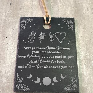 May include: Black slate sign with white text and illustrations. The text reads: "Always throw Spilled Salt over your left shoulder, keep Rosemary by your garden gate, plant Lavender for luck, and Fall in Love whenever you can."