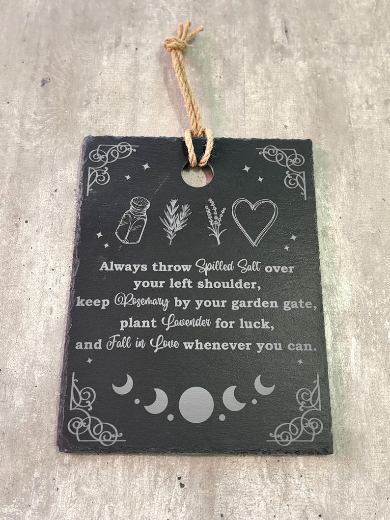 May include: Black slate sign with white text and illustrations. The text reads: "Always throw Spilled Salt over your left shoulder, keep Rosemary by your garden gate, plant Lavender for luck, and Fall in Love whenever you can."