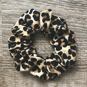 May include: A brown, black, and white leopard print scrunchie.