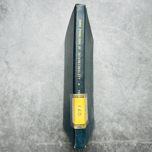 May include: A dark teal book titled "SOME PROBLEMS OF INTENSIONALITY" with gold lettering. A yellow sticker with the number "160" is affixed to the spine. The book's cover is a darker shade of teal.