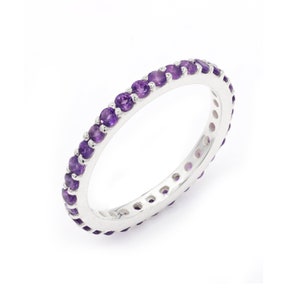 May include: A silver band ring with a row of small, round, purple amethyst gemstones.