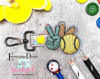 May include: A silver key chain with a peace sign and a baseball design. The peace sign is green and the baseball is yellow. The key chain is attached to a silver clip.