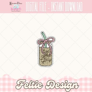 May include: An embroidered patch featuring a mason jar with coffee and a straw. The jar is tied with a pink bow and the text "Food Coffee Girly" is written on the front. The design is on a light pink background.