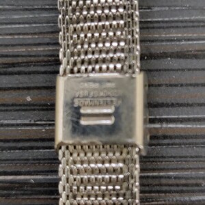 May include: Silver metal watch band with a clasp that reads "GENUINE STAINLESS STEEL CASE NO. 154".