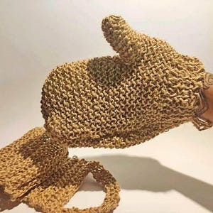 Peut inclure: Un gant de toilette tricoté de couleur beige avec une section pour le pouce et une sangle de bain rectangulaire assortie dotée d'une poignée en boucle à une extrémité. Les articles sont fabriqués en fibre naturelle avec un tissage ouvert.