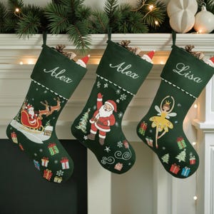 Puede incluir: Tres calcetines navideños verde oscuro cuelgan de una repisa. Cada calcetín está personalizado con un nombre en escritura blanca. Uno presenta a Papá Noel en su trineo, otro a Papá Noel saludando y el tercero a una bailarina. Regalos y copos de nieve decoran los calcetines.
