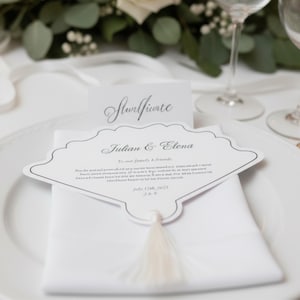 May include: A white wedding place setting with a decorative card that reads "Julian & Elena" and a tassel. The card is on top of a white napkin and a white plate. A smaller card with the word "Sturifunte" is in the background.