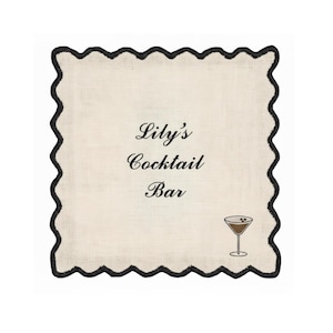 May include: Square cocktail napkin with a cream-colored center and a black scalloped border. The text "Lily's Cocktail Bar" is printed in black script. A small cocktail glass illustration is in the lower right corner.