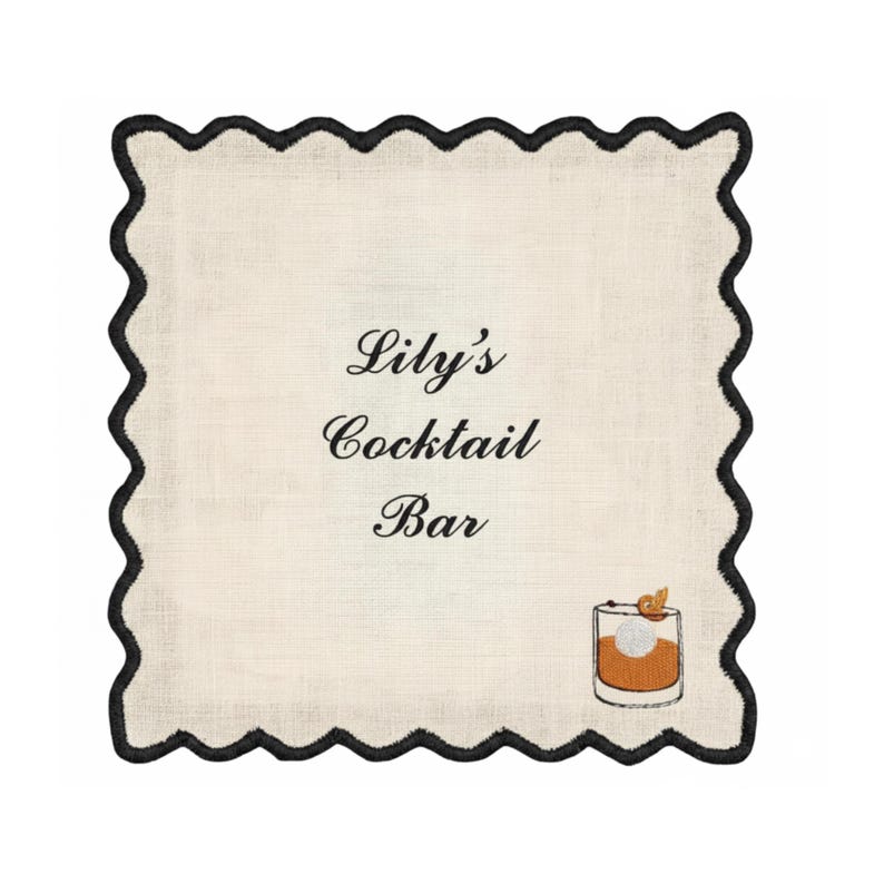 May include: A square, off-white cocktail napkin with a black scalloped border. The text "Lily's Cocktail Bar" is centered, with a graphic of a cocktail glass in the lower right corner. The napkin is made of a textured fabric.