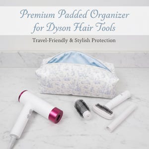 May include: A white and pink Dyson hair dryer and accessories are displayed with a patterned organizer bag. The bag is white with a blue toile print and a blue gingham interior. The text reads "Premium Padded Organizer for Dyson Hair Tools".