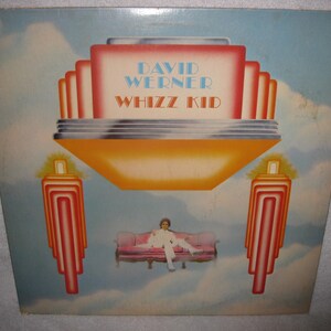 May include: Album cover art for "Whizz Kid" by David Werner. The artwork features a retro design with a stylized orange and red structure, the artist sitting on a pink couch, and the title text in blue and orange.