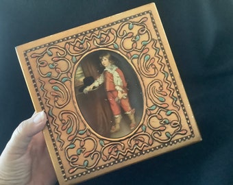 una lata vintage de parein en forma de caja florentina que representa un cuadro de Lamote Alidor: Retrato de Carlos II cuando era niño.