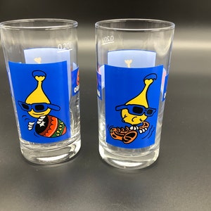 2 Orangina glasses with an  orangina bottle playing the saxophone and the djembe